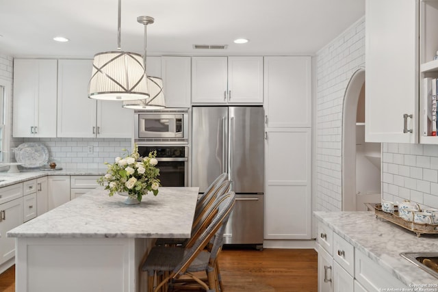 643 Terrell Rd, Terrell Hills, TX 78209 - kitchen with stainless steel appliances, white cabinetry, backsplash, arched walkways, and recessed lighting
