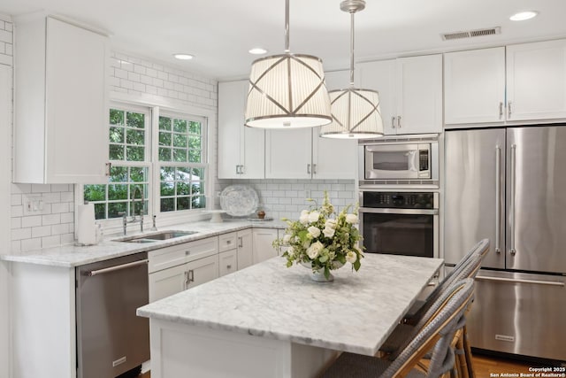 643 Terrell Rd, Terrell Hills, TX 78209 - kitchen featuring stainless steel appliances, a sink, white cabinetry, light stone countertops, and tasteful backsplash