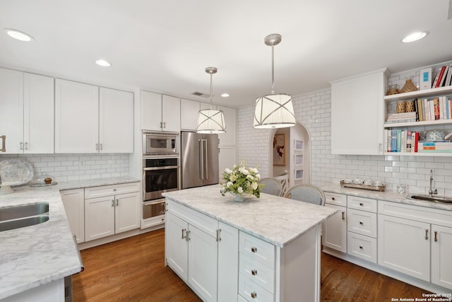 643 Terrell Rd, Terrell Hills, TX 78209 - kitchen with appliances with stainless steel finishes, decorative backsplash, a sink, white cabinets, and a center island