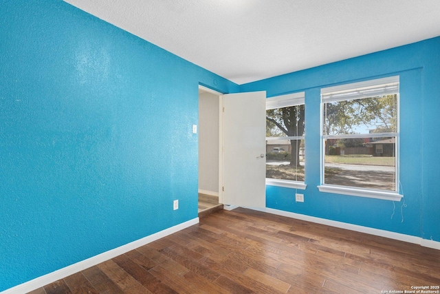 unfurnished room featuring baseboards and wood finished floors
