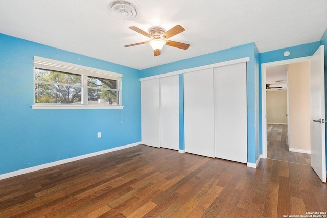 unfurnished bedroom featuring baseboards, wood finished floors, visible vents, and a closet