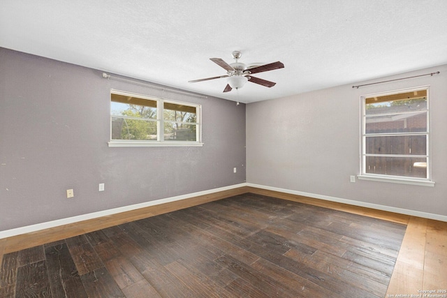 empty room with ceiling fan, baseboards, and hardwood / wood-style floors