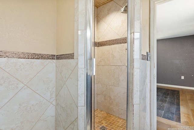 bathroom featuring wood finished floors and a stall shower
