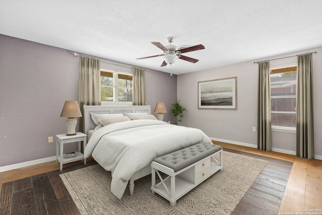 bedroom featuring hardwood / wood-style floors, a ceiling fan, and baseboards