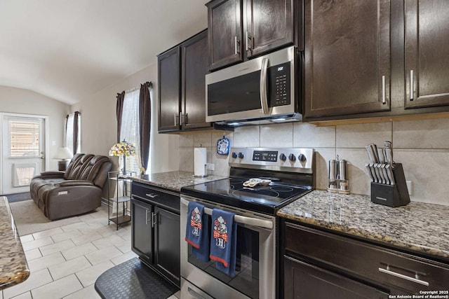8018 Radiant Sunset, San Antonio, TX 78252 - kitchen with light stone countertops, dark brown cabinetry, vaulted ceiling, stainless steel appliances, and open floor plan