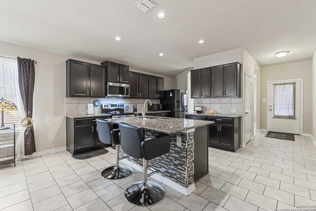 8018 Radiant Sunset, San Antonio, TX 78252 - kitchen featuring stainless steel appliances, visible vents, baseboards, and backsplash