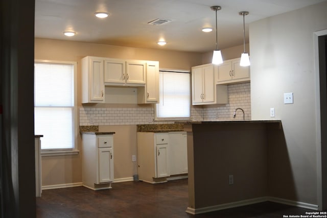 390 Harcourt, San Antonio, TX 78223 - kitchen featuring tasteful backsplash, visible vents, white cabinets, and a sink