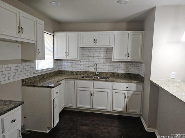 390 Harcourt, San Antonio, TX 78223 - kitchen with dark wood-style flooring, white cabinetry, a sink, and backsplash