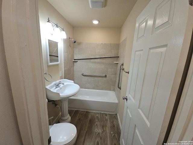 390 Harcourt, San Antonio, TX 78223 - bathroom with toilet, bathtub / shower combination, and wood finished floors