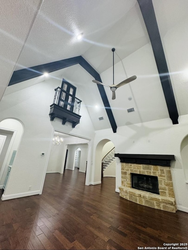 8118 Vanity, San Antonio, TX 78256 - unfurnished living room with visible vents, arched walkways, a stone fireplace, ceiling fan, and high vaulted ceiling