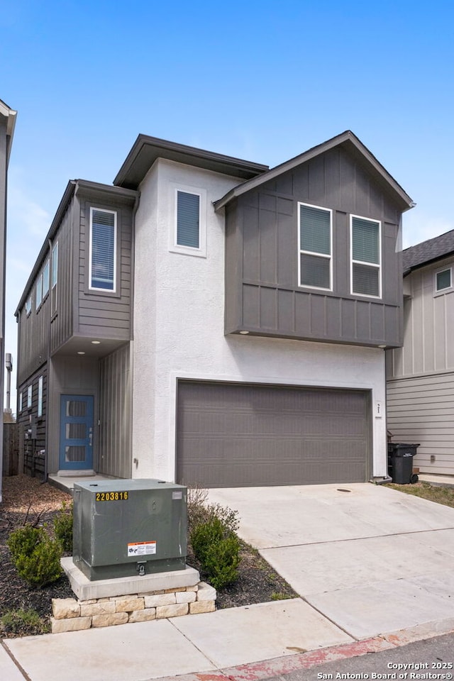 view of front facade with an attached garage, board and batten siding, concrete driveway, and stucco siding