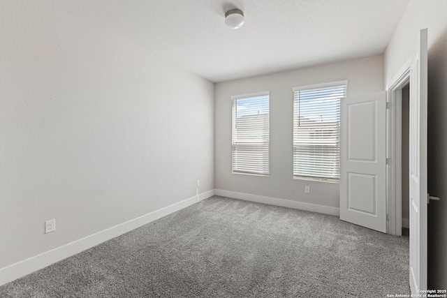 empty room featuring carpet floors and baseboards