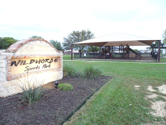 community sign with a yard and fence