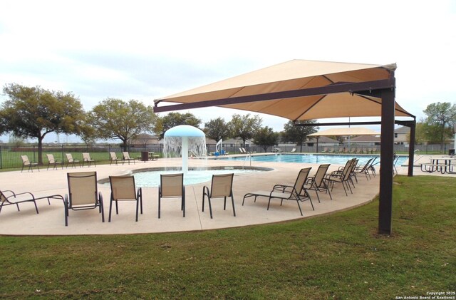 pool featuring a patio area, fence, and a lawn