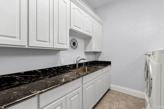 laundry room featuring washer / clothes dryer, light tile patterned flooring, a sink, baseboards, and cabinet space