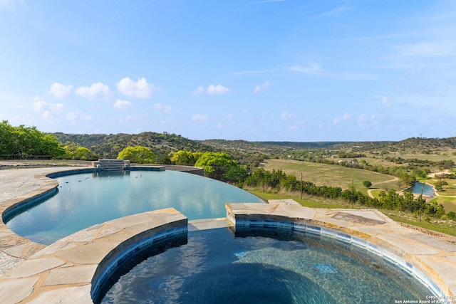 view of swimming pool featuring a pool with connected hot tub and fence