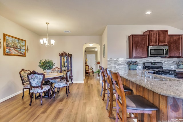 8926 Double Oak, San Antonio, TX 78254 - kitchen with tasteful backsplash, baseboards, arched walkways, a sink, and stainless steel appliances