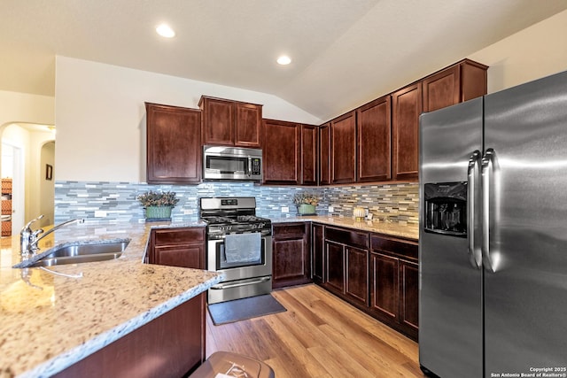 8926 Double Oak, San Antonio, TX 78254 - kitchen featuring a sink, light wood-type flooring, vaulted ceiling, light stone countertops, and stainless steel appliances