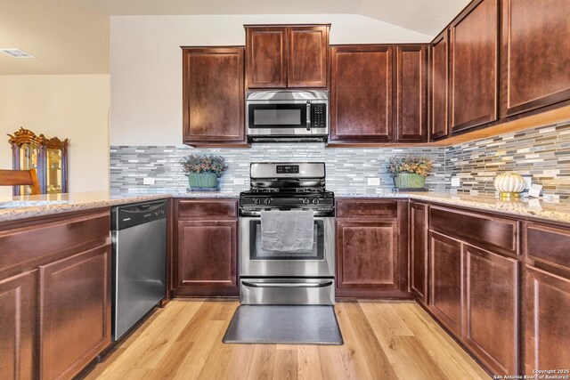 8926 Double Oak, San Antonio, TX 78254 - kitchen with light stone counters, light wood-style floors, visible vents, decorative backsplash, and stainless steel appliances