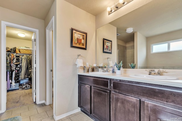 8926 Double Oak, San Antonio, TX 78254 - bathroom featuring double vanity, a sink, tile patterned flooring, and a walk in closet