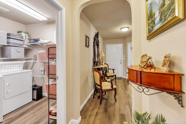 8926 Double Oak, San Antonio, TX 78254 - hallway featuring washer and dryer, arched walkways, and wood finished floors