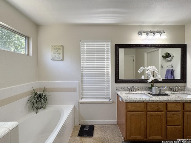 8418 Hera, Universal City, TX 78148 - full bathroom with double vanity, a garden tub, baseboards, and a sink
