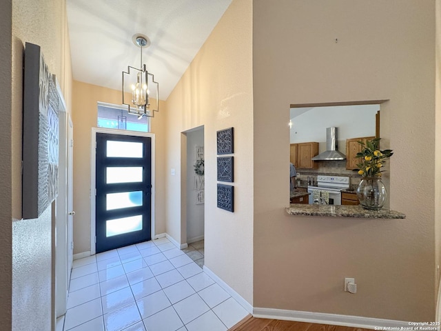 8418 Hera, Universal City, TX 78148 - entryway featuring a chandelier, light tile patterned flooring, a towering ceiling, and baseboards