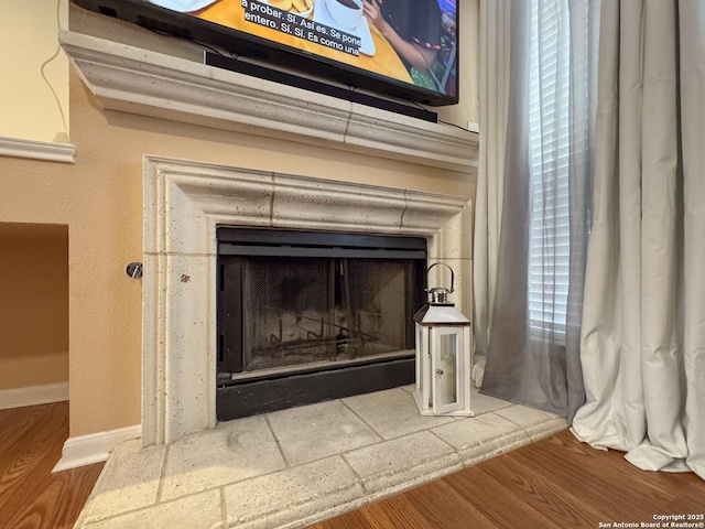 8418 Hera, Universal City, TX 78148 - details with a fireplace with raised hearth, baseboards, and wood finished floors