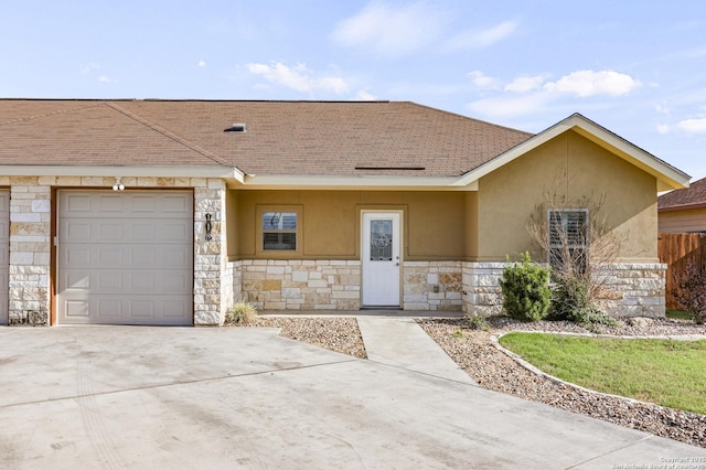 ranch-style home featuring driveway, stucco siding, stone siding, and a garage