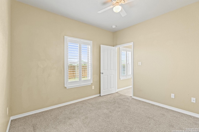 unfurnished room featuring carpet flooring, baseboards, and ceiling fan