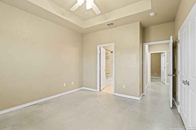 unfurnished bedroom featuring concrete floors, baseboards, connected bathroom, visible vents, and a raised ceiling