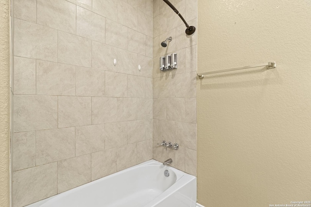 bathroom featuring shower / bath combination and a textured wall