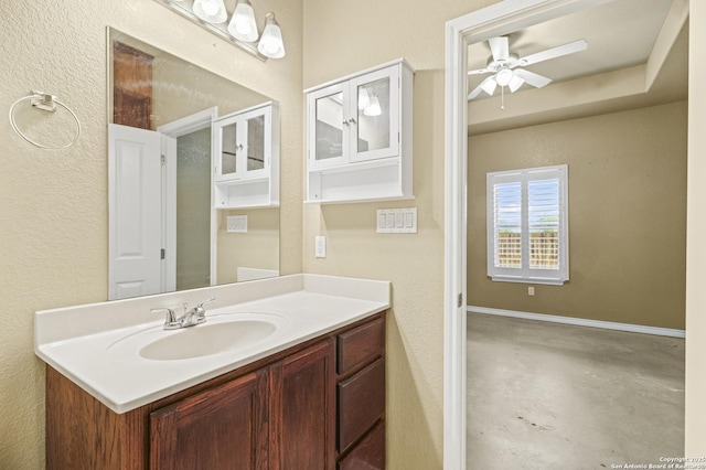bathroom featuring a textured wall, concrete floors, vanity, and ceiling fan