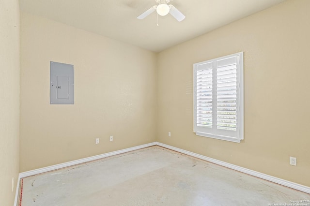 spare room with concrete flooring, ceiling fan, electric panel, and baseboards