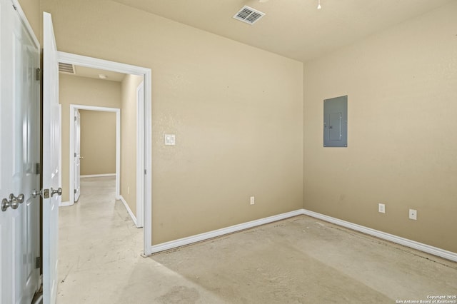 empty room with concrete floors, visible vents, and electric panel