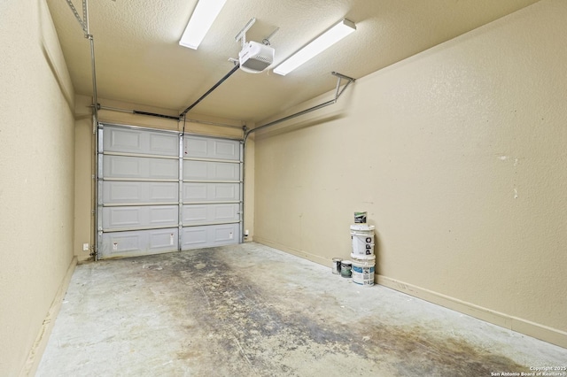 garage with baseboards and a garage door opener