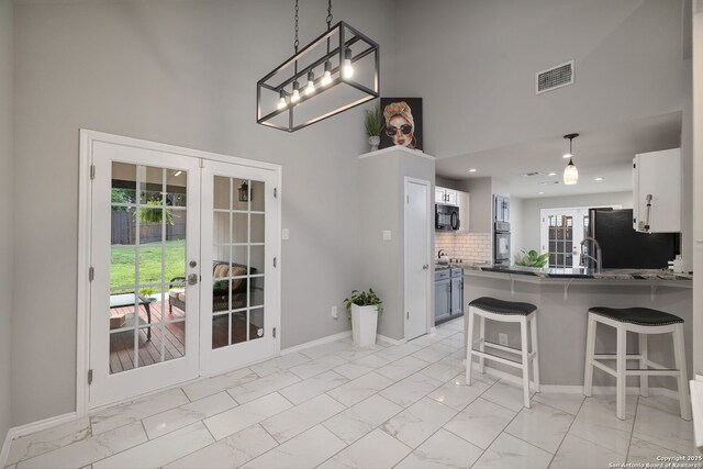7507 Silent Cloud, San Antonio, TX 78250 - kitchen featuring french doors, black microwave, wall oven, a towering ceiling, and light marble finish floors