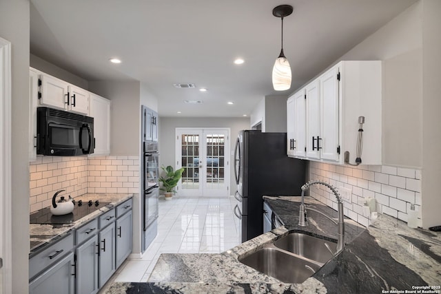 7507 Silent Cloud, San Antonio, TX 78250 - kitchen with black appliances, a sink, stone counters, white cabinets, and decorative backsplash