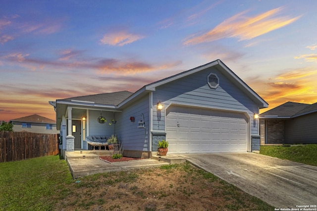 ranch-style home featuring a front yard, fence, a garage, and concrete driveway