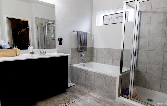 13511 Pickett, San Antonio, TX 78254 - full bath featuring vanity, a spacious closet, a shower stall, a bath, and wood finished floors
