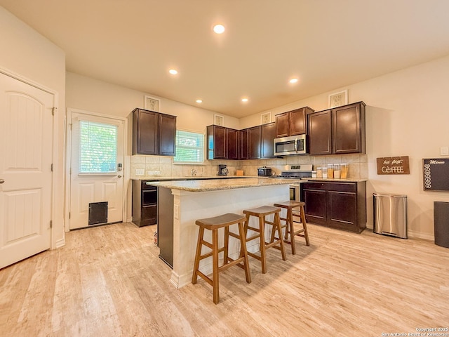 13511 Pickett, San Antonio, TX 78254 - kitchen with light wood-style flooring, appliances with stainless steel finishes, decorative backsplash, and dark brown cabinetry