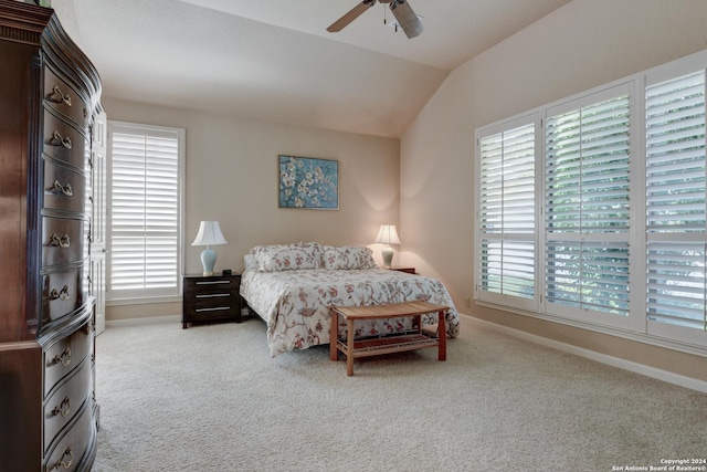carpeted bedroom featuring baseboards, multiple windows, vaulted ceiling, and ceiling fan
