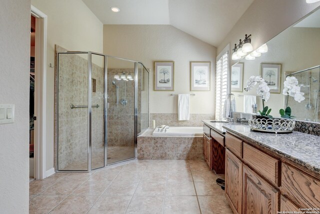 bathroom with a garden tub, vanity, tile patterned flooring, lofted ceiling, and a stall shower