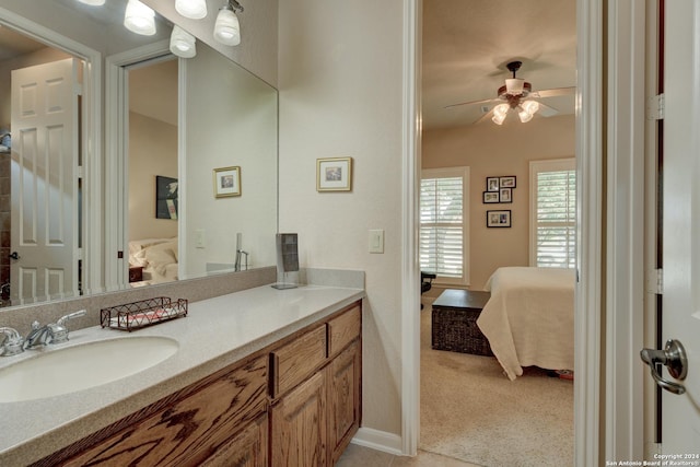 bathroom with ensuite bathroom, baseboards, a ceiling fan, and vanity
