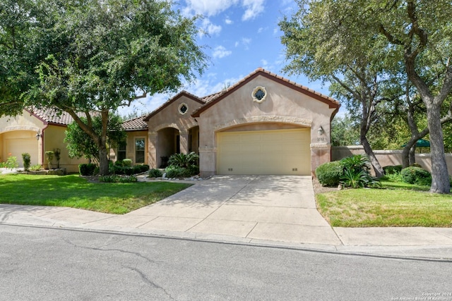 mediterranean / spanish-style home featuring a tiled roof, an attached garage, stucco siding, a front lawn, and driveway