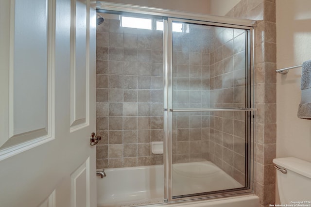 full bath with shower / bath combination with glass door and toilet