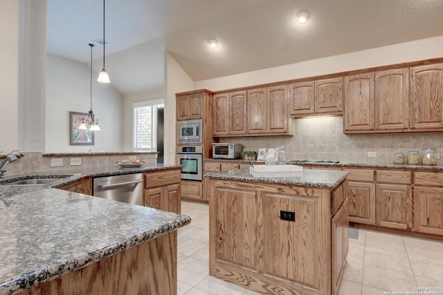 kitchen featuring tasteful backsplash, a center island, a sink, stainless steel appliances, and stone countertops