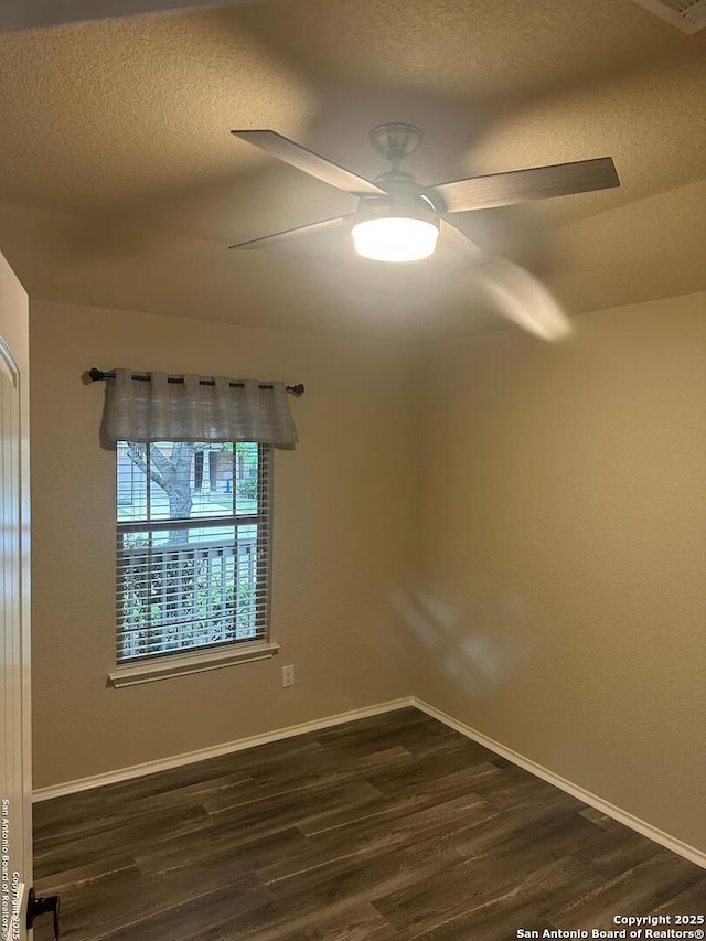 spare room with dark wood-type flooring, a textured ceiling, and ceiling fan