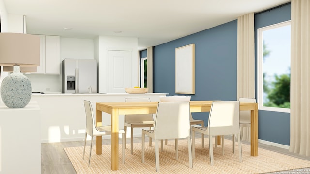 dining space with light wood finished floors and baseboards