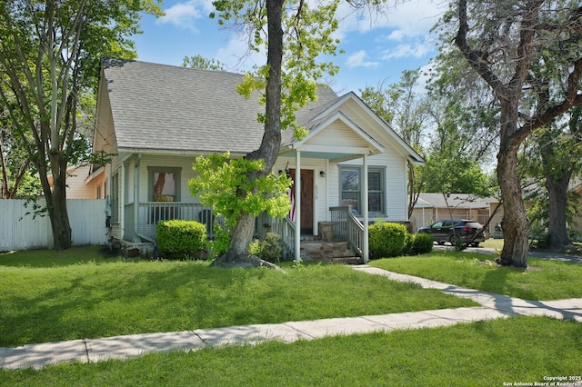 636 W Hollywood Ave, San Antonio, TX 78212 - view of front of property featuring roof with shingles, a porch, fence, and a front yard